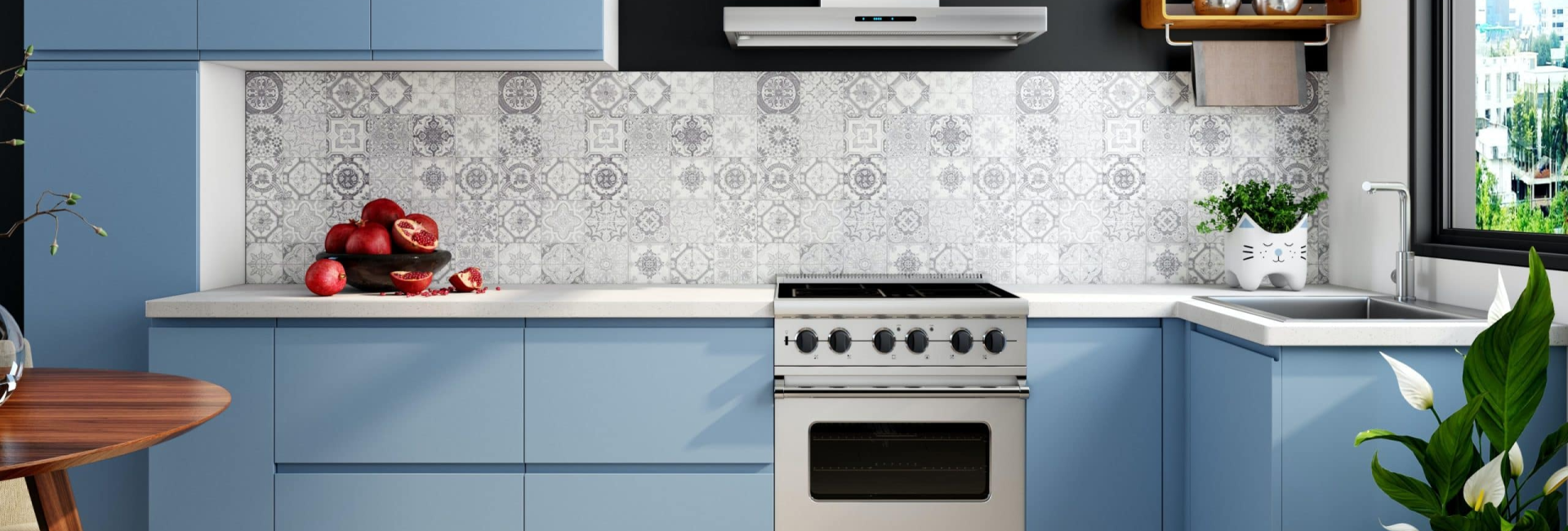 Modern kitchen with blue cabinets, pomegranate on counter, patterned tiles, wine rack and view from window