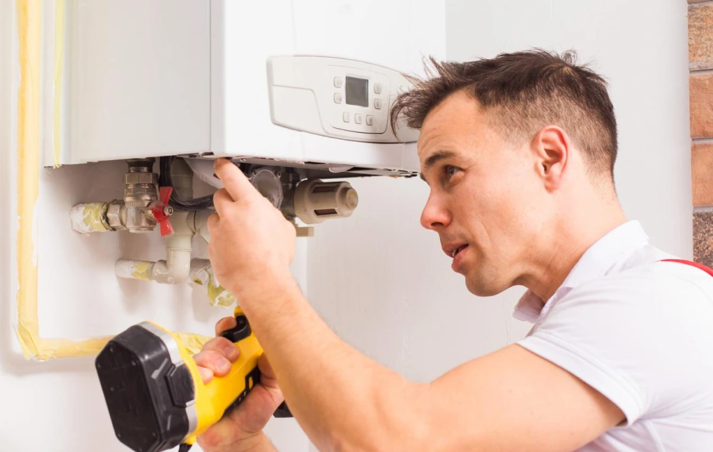 Technician inspecting a boiler unit with a flashlight, ensuring proper maintenance and functionality in home setting