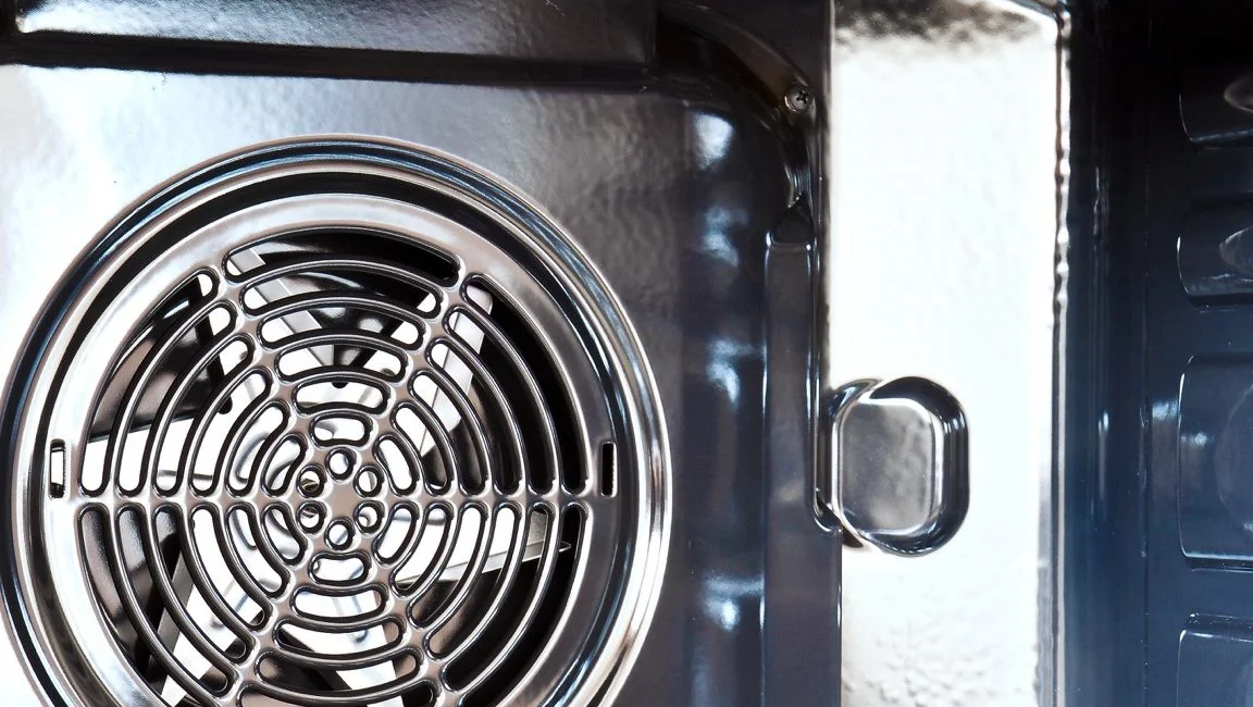 Close-up view of stainless steel oven interior with heating element and fan showing clean, modern design