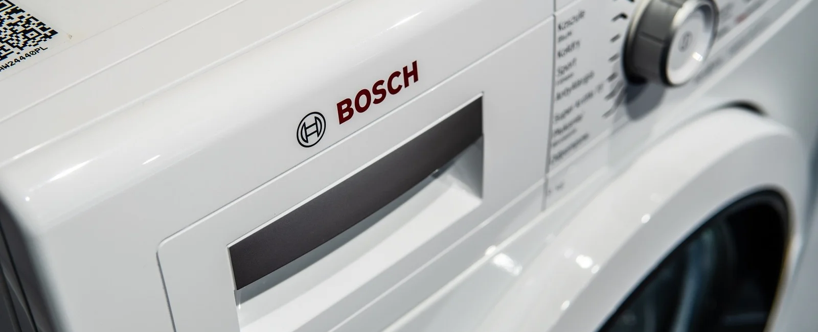 Close-up of a Bosch washing machine's control panel and detergent drawer, highlighting brand and modern design