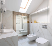 Luxurious marble bathroom with modern fixtures, skylight, and minimalist design in a compact space