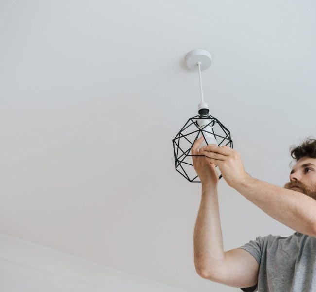Man screwing light bulb into lamp