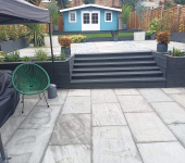 Modern garden with patio, contemporary seating, and stylish shed in landscaped backyard setting