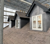 Roof renovation with scaffolding and dormer windows under construction in the UK
