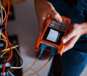 Person using network cable tester for electrical system diagnostics