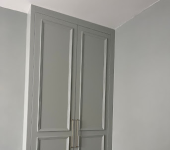 Grey wardrobe with paneled doors in modern interior design setting