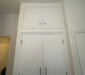 Tall white cupboard doors in a modern interior, showcasing minimalist design and ample storage space