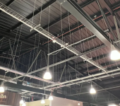 Modern industrial ceiling with exposed beams and hanging lights in a commercial building interior