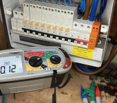 Electrical fuse box with circuit breakers and multimeter testing device, featuring wires and connectors