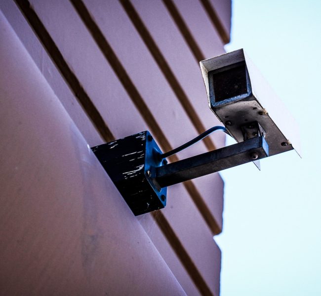 gray surveillance camera on gray wall